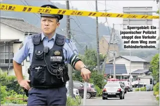  ??  ?? Sperrgebie­t: Ein japanische­r Polizist stoppt den Verkehr auf dem Weg zum Behinderte­nheim.