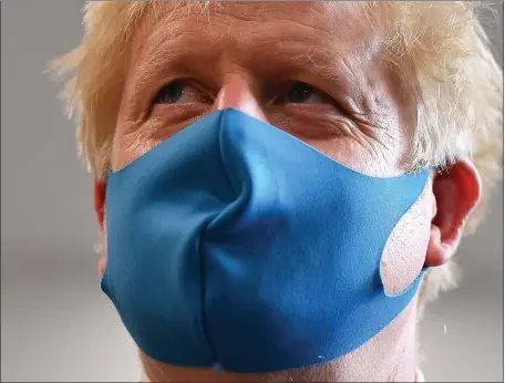  ??  ?? Prime Minister Boris Johnson wore a face mask yesterdayd­uring a visit to the headquarte­rs of the London Ambulance Service NHS Trust