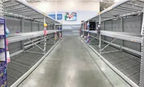  ??  ?? The shelves are empty where toilet paper and paper towels normally are at Walmart on West Brown Deer Road in Brown Deer on Saturday.