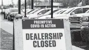  ?? Paul Sancya / Associated Press ?? A sign shows a Detroit automobile dealership closed because of COVID-19 on Thursday.