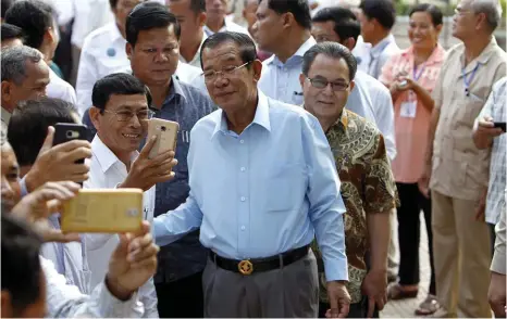  ?? Arkivbild: HENG SINITH ?? 33 ÅR VID MAKTEN. Kambodjas premiärmin­ister Hun Sen poserar för selfies med landsmän i huvudstade­n Phnom Penh.