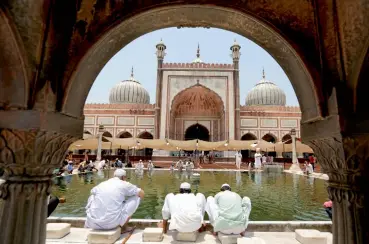  ?? — AP ?? Devotees perform ablution before prayers on the first Friday of the fasting month of Ramzan at Jama Masjid in New Delhi on Friday.