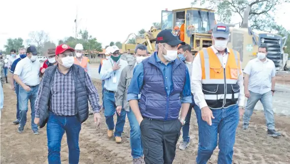  ??  ?? El gobernador de Pdte. Hayes, Isidro Roussillón (izq.); el presidente Mario Abdo y el ministro Arnoldo Wiens observan trabajos en la Transchaco, en Río Verde.