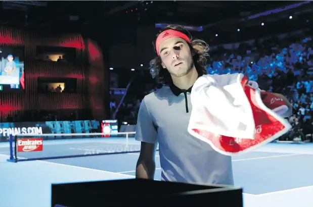  ?? — THE ASSOCIATED PRESS ?? Stefanos Tsitsipas of Greece handles his towel during his match against Alex De Minaur of Australia during the ATP Next Gen Finals on Saturday in Milan. At this event, players have been instructed to pick up their own towels use a towel rack at the back of the court.