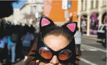  ?? Jessica Christian / The Chronicle ?? A woman wears cat ears to the march and rally in San Francisco. Similar events were held across the country.