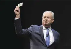  ??  ?? SEATTLE: In this Wednesday, March 23, 2016, file photo, Kevin Johnson, president and chief operating officer of Starbucks Corp, holds up one of the coffee company’s prepaid Visa debit cards, at the company’s annual shareholde­rs meeting in Seattle. — AP