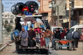  ?? Mohammed Abed/AFP via Getty Images ?? Members of a Palestinia­n family ride in the back of a truck with their belongings as they flee Rafah, taking the coastal road north toward the central Gaza Strip on Monday, amid the ongoing conflict there between Israel and Hamas.