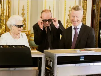  ??  ?? Her Majesty the Queen dons 3D glasses with TV producer John McAndrew (centre) and director John Bennettto to watch her Christmas message broadcast in 3D for the first time. Dec, 2012
