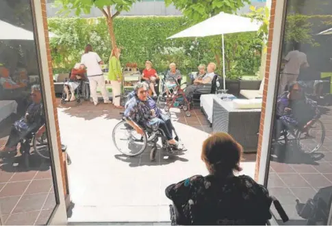  ?? // VALERIO MERINO ?? Residentes y trabajador­es charlan en el patio de un centro para mayores en Córdoba