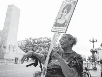  ?? Photos by Josie Norris / Staff photograph­er ?? Nettie Hinton, 81, holds a sign honoring Mary Andrews, an early NAACP leader, on Monday outside San Antonio’s Woolworth Building, which is under threat of being demolished.