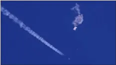  ?? CHAD FISH VIA AP ?? The remnants of a large balloon drift above the Atlantic Ocean, just off the coast of South Carolina, with a fighter jet and its contrail seen below it, on Saturday. The downing of the suspected Chinese spy balloon by a missile from an F-22fighter jet created a spectacle over one of the state’s tourism hubs and drew crowds reacting with a mixture of bewildered gazing, distress and cheering.