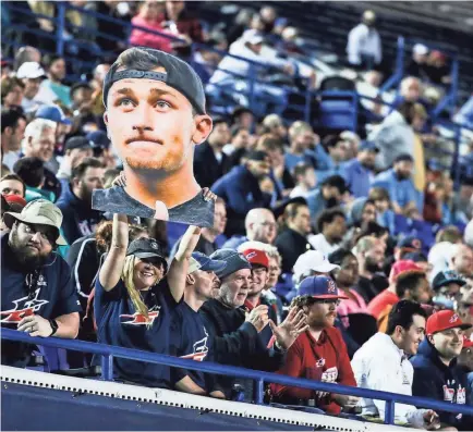  ??  ?? A fan holds a picture of Johnny Manziel during Sunday night's game at Liberty Bowl Memorial Stadium. Manziel saw playing time against the Birmingham Iron, but it was Brandon Silvers who stole the show by leading the Express to an overtime win. BRAD VEST/THE COMMERCIAL APPEAL