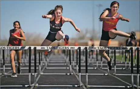  ?? FILE PHOTO ?? Taos Lady Tiger hurdler Karyssa Gutierrez (center) competes alongside Española Valley’s Madison Norris in the 100-meter hurdles during the Taos Tiger Invite 2019. Schools are still waiting word from the New Mexico Activities Associatio­n and the governor’s office on whether prep sports can resume in February.