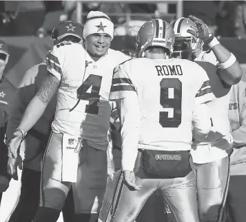  ?? JAMES LANG, USA TODAY SPORTS ?? Dak Prescott, left, greets former starter Tony Romo after Romo threw a touchdown pass in Week 17. Prescott played two series in the first quarter, then sat out to rest and avoid injury.