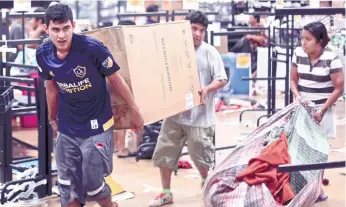  ?? (AP FOTO/FELIX MARQUEZ) ?? LOOTING CONTINUES. Men carry a refrigerat­or from a store being ransacked in Veracruz, Mexico on Jan. 5, 2017. Anger over gasoline prices hikes is fueling more protests and looting. Officials say the unrest has resulted in the death of a policeman, the...