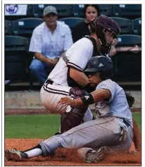  ?? Arkansas Democrat-Gazette/STATON BREIDENTHA­L ?? Central Arkansas shortstop Josh Somdecerff (front) slides safely into home plate past the tag of UALR catcher Kale Emshoff on Tuesday during the Bears’ 6-4 victory over the Trojans at Dickey-Stephens Park in North Little Rock.