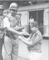  ?? - BHUSHAN KOYANDE ?? Appreciati­ng the courage: A girl ties a rakhi to security personnel at CST on the auspicious Raksha Bandhan.