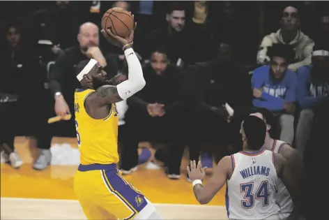  ?? MARCIO JOSE SANCHEZ/AP ?? LOS ANGELES LAKERS FORWARD LEBRON JAMES (left) scores to pass Kareem Abdul-jabbar to become the NBA’S all-time leading scorer as Oklahoma City Thunder guard Josh Giddey (right) and forward Kenrich Williams defend during the second half of a game on Tuesday in Los Angeles.