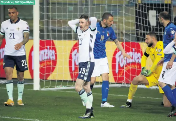  ?? WILLIAM CHERRY/PRESSEYE ?? So close:
Northern Ireland’s Micheal Smith holds his head after Italy’s Gianluigi Donnarumma saves his shot