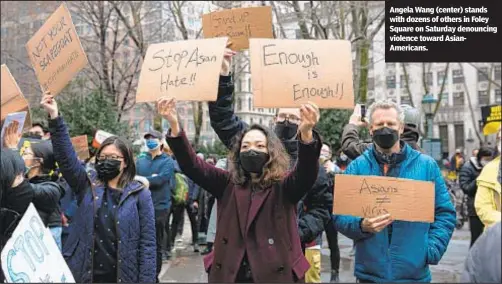  ??  ?? Angela Wang (center) stands with dozens of others in Foley Square on Saturday denouncing violence toward AsianAmeri­cans.