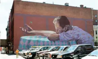  ??  ?? A mural by the artist Bezt rises above a parking lot in downtown Providence, RI. — AP photos
