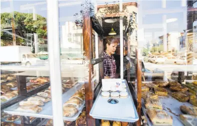  ?? Noah Berger / Special to The Chronicle ?? Rosa Maria, who has worked at La Victoria Bakery in San Francisco for 20 years, stocks pastries on Monday. One of the first Mexican-owned businesses on 24th Street, La Victoria is closing after 67 years.