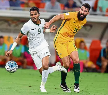  ?? — AFP ?? Halt!: Australia’s Mile Jedinak (right) trying to stop Saudi’s Nawaf Alabid during their World Cup qualifier at the King Abdullah Sports City Stadium in Jeddah on Thursday.