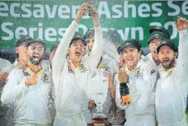  ??  ?? Australia's captain Tim Paine lifts the Ashes urn aloft at the Oval.
AFP