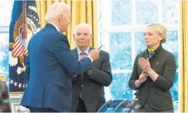  ?? MANUEL BALCE CENETA/AP ?? President Joe Biden hands the pen he used to sign the Ukraine bill to Ukraine-born Rep. Victoria Spartz, R-Ind., while Sen. Ben Cardin, D-Md., looks on.