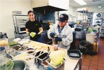  ?? RICHARD VOGEL/AP ?? Anna Le Nguyen and Minh Rasavong Oriyavong help out Dec. 20 in the Love & Thai kitchen in Fresno, Calif.