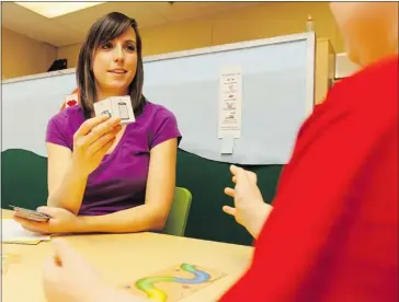  ?? Stuart Gradon/calgary Herald ?? Lyndsey Graham, speech language pathologis­t assistant, leads a student through an exercise at EvenStart preschool.