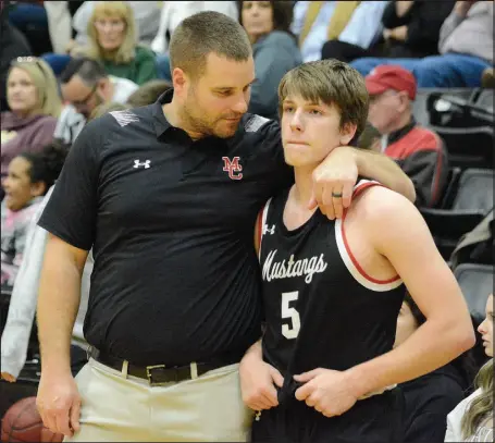  ?? Bennett Horne/McDonald County Press ?? McDonald County head coach Brandon Joines consoles Mustang senior guard Cross Dowd in the final seconds of their 60-43 season-ending loss to Hillcrest in the Class 5 District 6 Basketball Tournament at Willard on Wednesday, March 1.