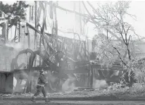  ?? AP FILE PHOTO ?? A firefighte­r walks past what the remains of the American Shakespear­e Theatre in Stratford.