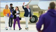  ?? MATTHEW HINTON — THE ASSOCIATED PRESS ?? New LSU coach Brian Kelly gestures to fans after his arrival at Baton Rouge Metropolit­an Airport on Tuesday.