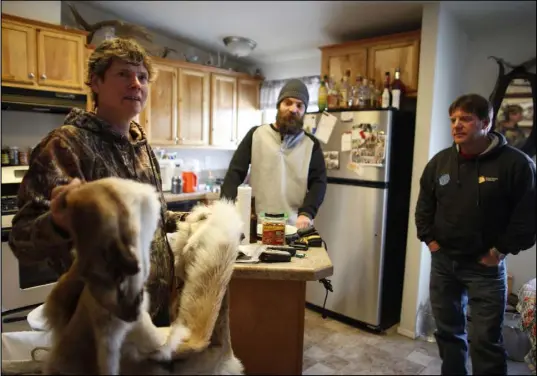  ??  ?? Letha Roberson holds the skin of a mountain lion next to Glen Stoner and his father, Donnie Stoner, on Jan. 18 at Roberson’s home in the Big Smoky Valley.