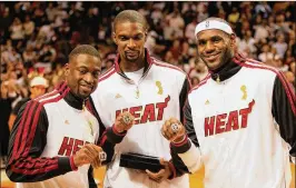 ?? CHRIS TROTMAN / GETTY IMAGES ?? Dwyane Wade (from left), Chris Bosh and LeBron James show off their 2012 championsh­ip rings. The Heat’s Big Three appeared in four straight Finals.