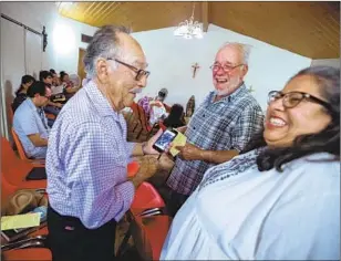  ?? Brian van der Brug Los Angeles Times ?? ANDREW LEDESMA, left, and Chris Vigil, right, share quake stories at their church’s first Mass since two temblors struck their small mining town over the Fourth of July weekend.