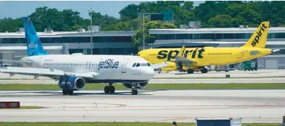  ?? WILFREDO LEE/AP ?? A JetBlue plane passes a Spirit jet at Fort Lauderdale-Hollywood Internatio­nal Airport in October 2022. A merger of the two airlines would have a significan­t impact on Florida airports in Orlando and Fort Lauderdale. Combined, the airlines had 557,000 passengers departing the airport in January.