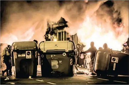  ?? LLIBERT TEIXIDÓ ?? Barricadas con contenedor­es y fuego en el Eixample de Barcelona el pasado viernes