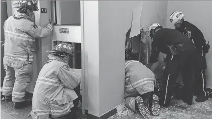  ?? SCOTT STILBORN ?? Ottawa fire crews cut openings to free an inspector trapped under an elevator Friday.