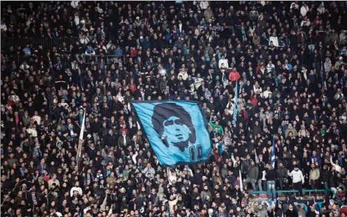  ?? (AFP) ?? In this file photo taken on January 7, 2013, SSC Napoli’s fans display a flag with the effigy of Napoli’s former Argentinia­n player Diego Armando Maradona during the Serie A match vs AS Roma at San Paolo Stadium in Naples.