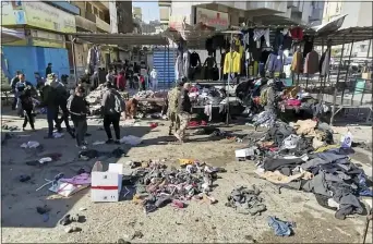  ?? HADI MIZBAN — THE ASSOCIATED PRESS ?? A deadly bomb attack hit a market selling used clothes in Baghdad on Thursday. Civilians were killed and wounded; the Islamic State is suspected.