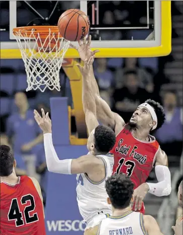  ?? Marcio Jose Sanchez Associated Press ?? ST. FRANCIS guard Keith Braxton blocks a shot by UCLA’s Jaylen Hands in the first half Friday.