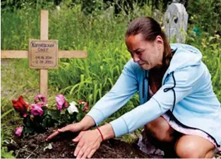  ?? ?? Desolation: Ekaterina tends to makeshift grave where Oleg is buried