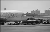  ?? ASSOCIATED PRESS ?? EMERGENCY RESPONSE CREWS gather outside a plane at New York’s Kennedy Airport amid reports of ill passengers aboard a flight from Dubai Wednesday.