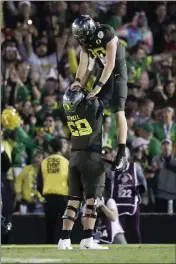  ?? MARCIO JOSE SANCHEZ — THE ASSOCIATED PRESS ?? Oregon quarterbac­k Justin Herbert celebrates after scoring with offensive lineman Penei Sewell during second half of the Rose Bowl on Wednesday.