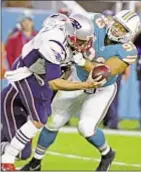  ?? AP ?? Tom Brady and the Patriots are sacked by Ndamukong Suh and the Dolphins on Monday night in South Florida.