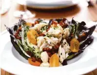  ??  ?? Blue crab wedge salad is prepared with local romaine, Benton’s bacon and blue-green goddess dressing.
