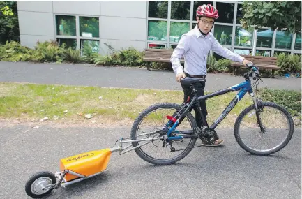  ?? DARREN STONE, TIMES COLONIST ?? UVic Engineerin­g student Simon Park with his prototype Caboost electric bike trailer.
