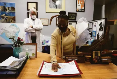  ?? Yalonda M. James / The Chronicle ?? Above: Dr. James Dahlgren watches as Dr. Ahimsa Porter Sumchai studies a Hunters Point map charting chemicals she suspects are doing harm.